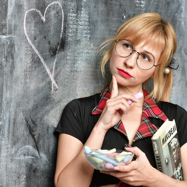学校通校对环节的桌面特写，一份打印稿上用红笔标注了需要核实来源的段落，旁边放着湖蓝色马克杯与钢笔